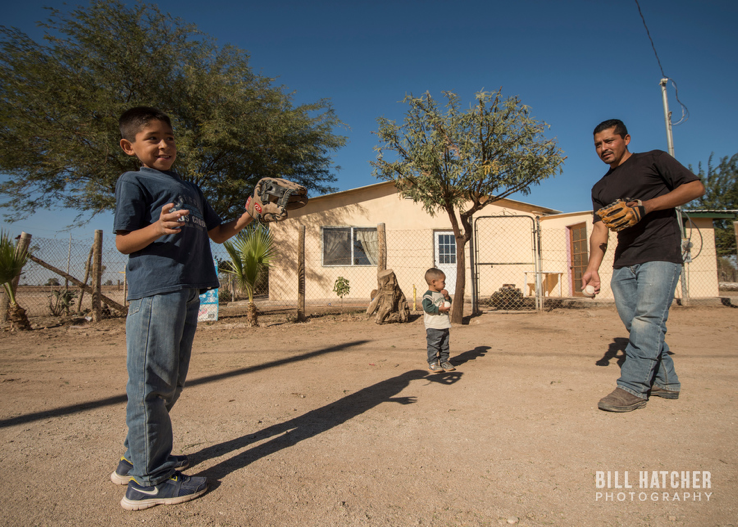 Photo by Bill Hatcher (Instagram: @bhatcherphoto). A father plays catch with his two children.
