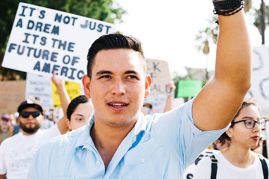 Man raises arm at an immigrant rights rally.