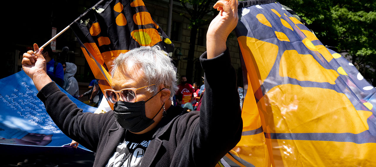 Woman holds butterfly wings at immigration rally.