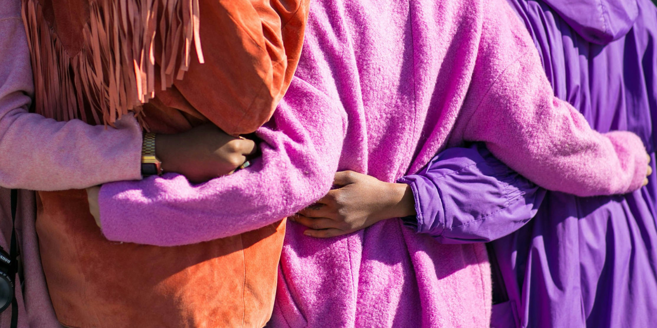 four people with their arms around each other